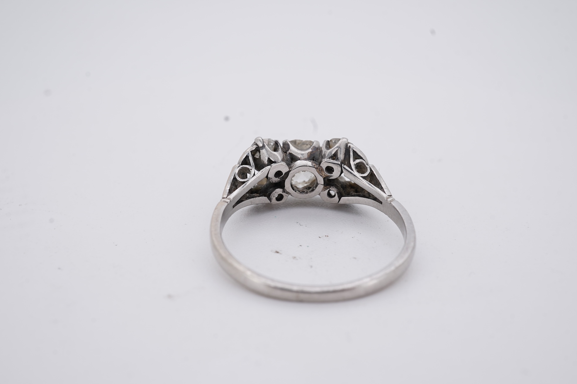A white metal (stamped platin) and single stone diamond ring, flanked by four smaller diamonds and rose cut diamond chip set shoulders, size P, gross weight 3.8 grams.